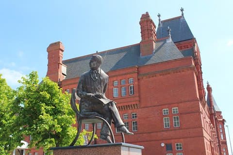 The statue of the welsh composer Ivor Novello in Cardiff Bay with the Pier Head Building behind.