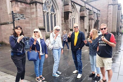 Tour guests enjoying a bite of an award winning pie outside St. John's Kirk