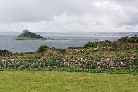 St. Michaels Mount with Mousehole and Penzance across Mounts Bay.