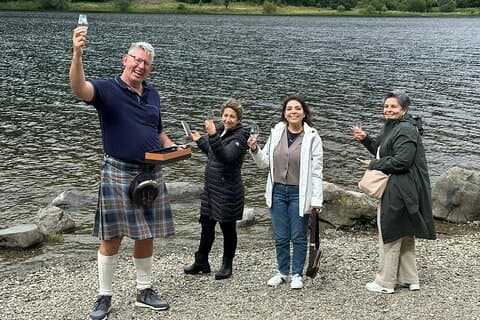 Bonnie Scotland Tours Nathan helping his guests enjoy a dram of whisky at Loch Lubnaig viewpoint in the Highlands of Scotland.