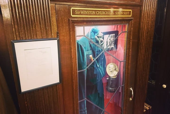 Winston Churchill's Tailors & one of his Siren Suits on display.
