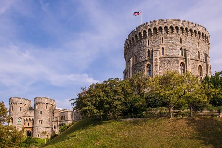 The Round Tower of Windsor Castle, crowned with the Union Jack, stands tall as a central landmark in this royal residence.