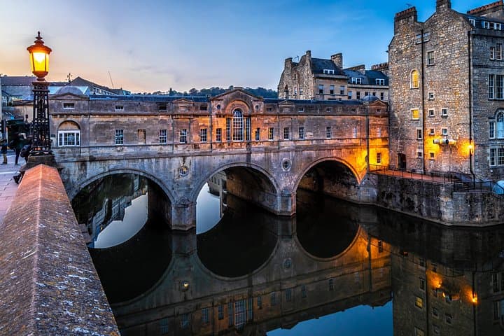 Pulteney Bridge in Bath glows in the evening light, its arches reflecting beautifully in the River Avon.