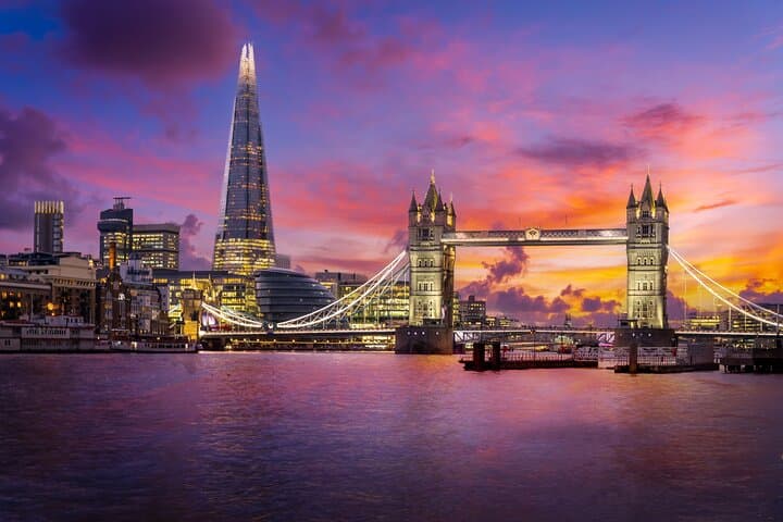 A stunning view of Tower Bridge and The Shard at sunset, showcasing the iconic landmarks of London reflected in the River Thames.