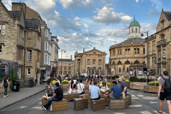 People enjoying the beers from the White Horse on Broad Street, with views of the Sheldonian Theatre in the background.