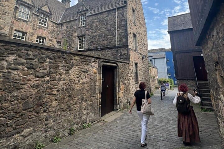 Charlotte and Visitor entering Bakehouse close, location for Jamie's Printshop in Outlander