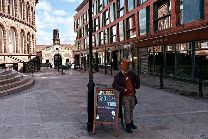 Lord Bartholomew Catch next to his ghost tour sign by a lamp post outside Leeds Corn Exchange