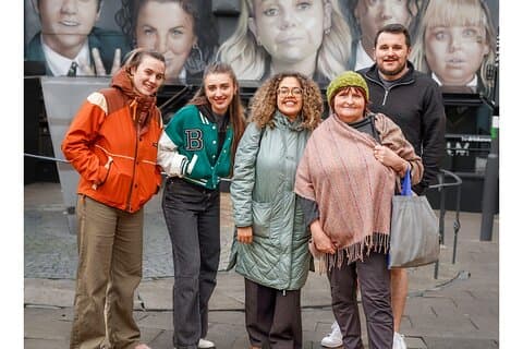 Students at the Derry Girls Mural with Guide Anne Crilly front right.